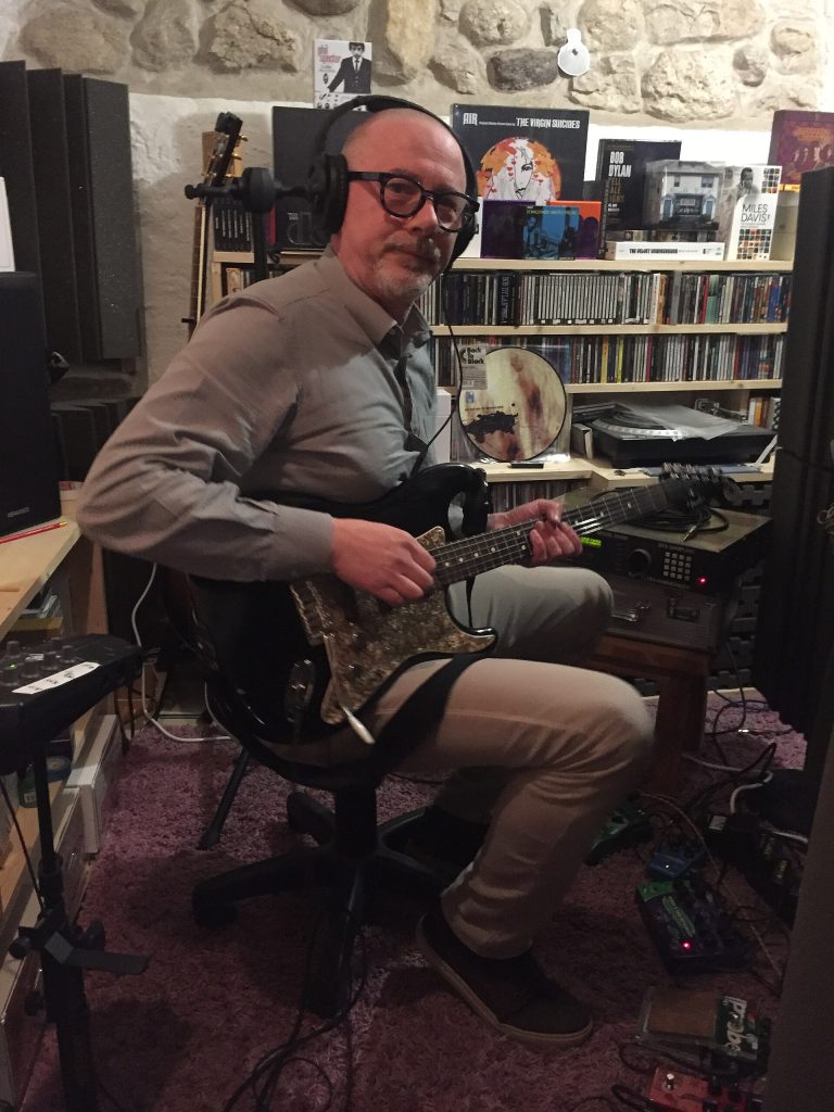 A musician recording with headphones in a studio